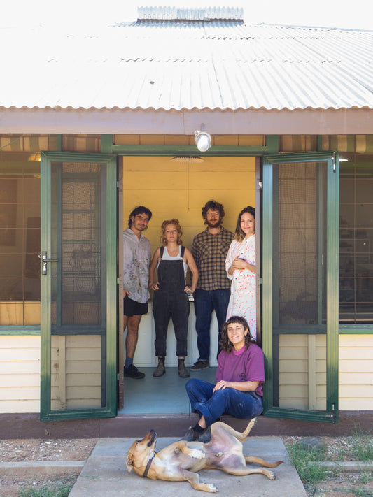 Bathhouse studios artists (five people) standing in a doorway with a dog rolling on it's back in the front
